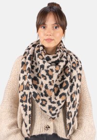 Écharpe en imprimé léopard beige, ornée de taches noires et brunes. Tissu doux et texturé, doté d'une forme triangulaire autour du cou.