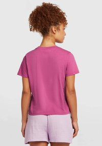 Pink short-sleeve t-shirt with a round neck, made of soft cotton, paired with light purple textured shorts.