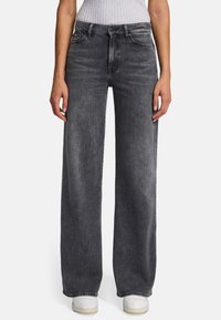 Jean large en denim gris foncé. Présente un design classique à cinq poches et une fermeture à bouton. L'ourlet est terminé par une surpiqûre subtile en contraste.