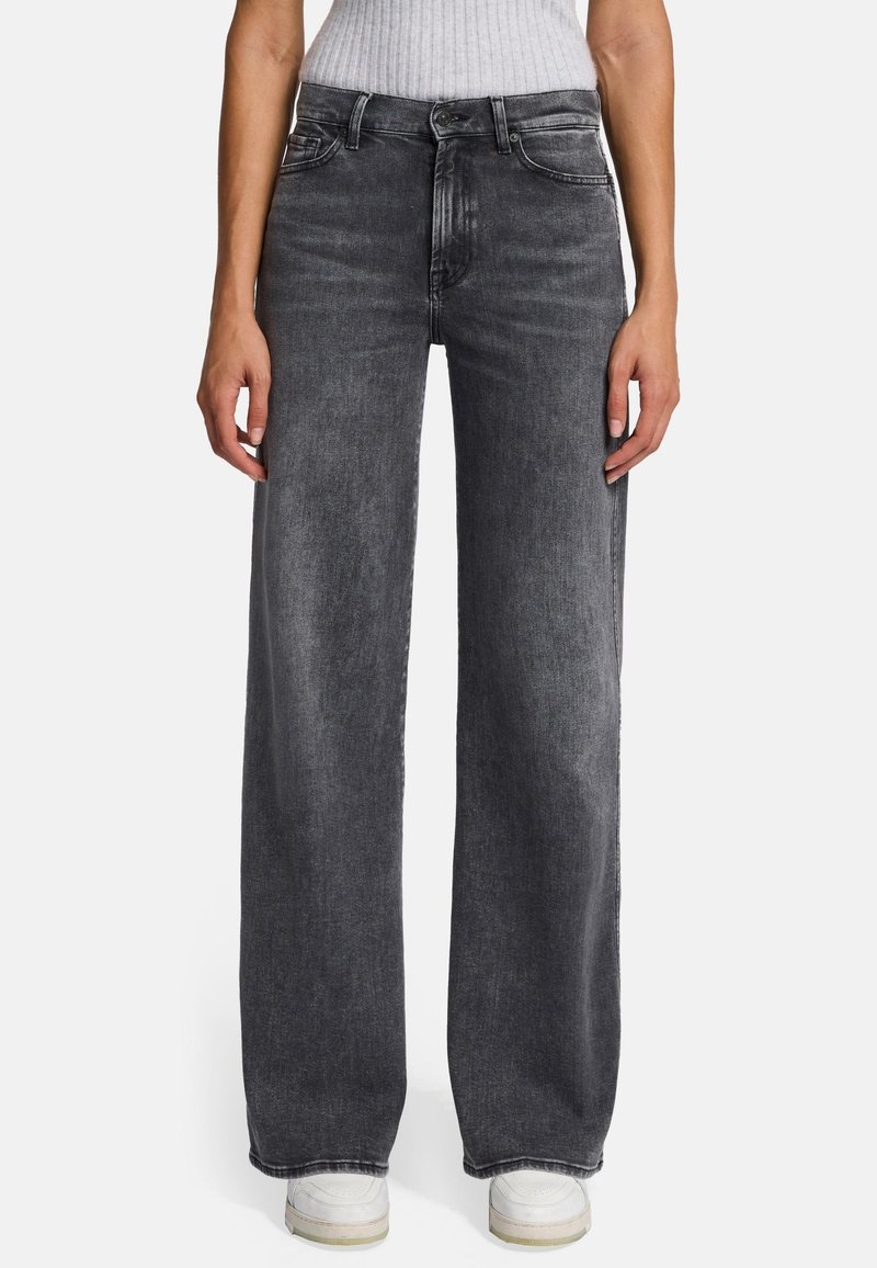 Jean large en denim gris foncé. Présente un design classique à cinq poches et une fermeture à bouton. L'ourlet est terminé par une surpiqûre subtile en contraste.