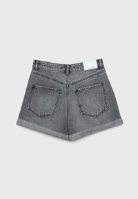 Vista trasera de unos pantalones cortos de mezclilla gris con dos bolsillos traseros, dobladillos enrollados, presillas para cinturón y una etiqueta blanca en la cinturilla, contra un fondo claro.