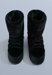 Sorte vinterstøvler foret med pels, rund tå, blød tekstur, justerbar snøring og en robust gummisål for godt fodfæste.