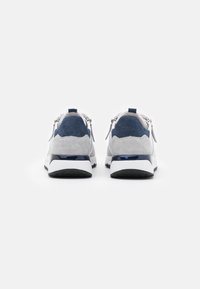 Sportskor med övre i grå mocka, marinblå detaljer och en svart gummisul med en slät, blank mellansula.