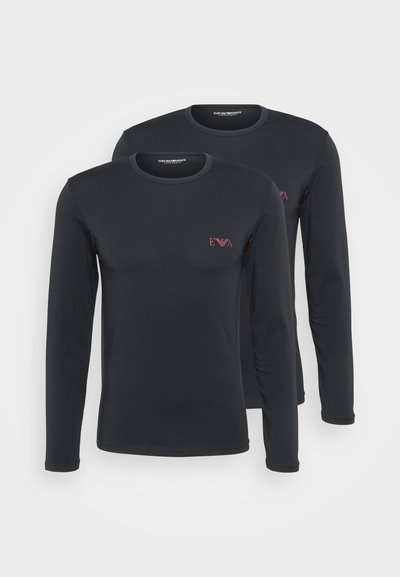 Deux chemises à manches longues noires en tissu lisse, arborant un petit logo rouge "EVA" sur la poitrine et un col rond classique.