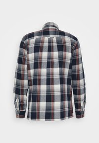 Camicia a quadri in navy, bianco e rosso con maniche lunghe, vista dal retro. La trama del tessuto appare morbida; presenta un colletto classico e un orlo curvo.