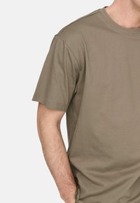 Olivenfarbene Baumwoll-T-Shirt mit kurzen Ärmeln und Rundhalsausschnitt, mit einer glatten Textur und lockerer Passform. Nähtdetails sichtbar.