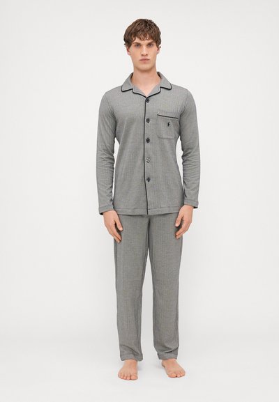 Ensemble de pyjama rayé gris avec manches longues et chemise à boutons ; il présente une poche poitrine et des bords contrastés noirs au col.