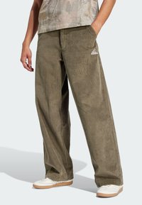 Olive green corduroy pants with wide legs, featuring vertical ridges, side pockets, and a white Adidas logo on the front.