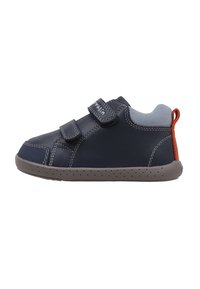 Zapato de cuero azul marino con acentos grises, correas de Velcro y suela de goma gris. Presenta una lengüeta trasera texturizada en naranja y detalles perforados.