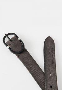 Grijze leren riem met een textuurafwerking, met een zwarte metalen gesp en gaten voor aanpassing. Merknamedruk op de band.