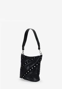 Bolso de hombro de cuero negro con una correa ancha, correas diagonales con tachuelas y detalles en hardware plateado.