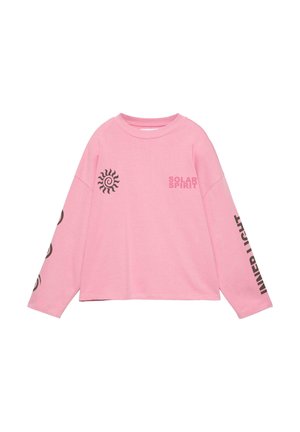 Rózsaszín hosszú ujjú póló fekete nap grafikával a mellkason, "SOLAR SPIRIT" felirattal, valamint "INNER LIGHT" felirattal, amely függőlegesen van nyomtatva a jobb ujján.
