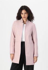 Cappotto di lana rosa chiaro con colletto rialzato, maniche lunghe e tasche laterali, caratterizzato da una silhouette slanciata e dritta.