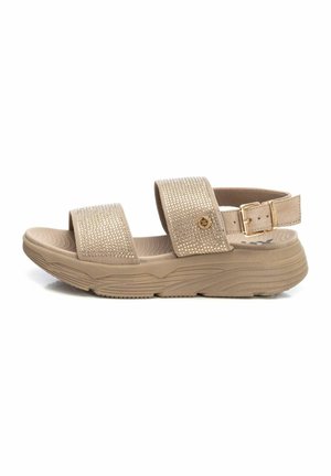 Sandal beige con dos correas anchas que presentan brillantes de cristal transparente, hebilla ajustable y suela texturizada para agarre y comodidad.