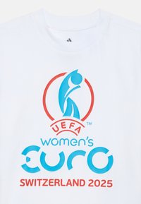 T-shirt en coton blanc avec un logo UEFA bleu, "EURO féminin" et "Suisse 2025" en texte rouge et bleu. Texture lisse.
