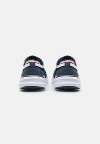 Scarpe da ginnastica blu navy con suola bianca, tomaia in rete e accenti rossi e bianchi in contrasto sul tallone e sul colletto.
