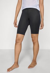 Schwarze Radshorts mit tailliertem Design, strukturiertem Stoff und einem zentralen Polsterausschnitt. Mittlere Oberschenkellänge und elastisches Material.