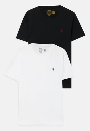 Två T-shirts staplade, en svart och en vit. Båda är gjorda av bomull med rund halsringning och har små broderade logotyper på bröstet.