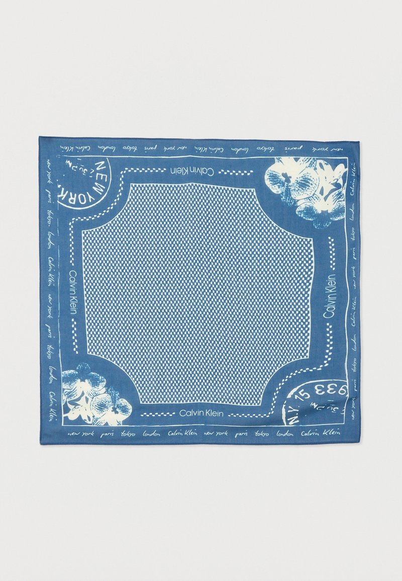 Μπλε κασκόλ Calvin Klein με λευκά λουλουδένια σχέδια, ονόματα πόλεων και γραμματόσημα τύπου ταχυδρομείου κατά μήκος του περιγράμματος και στο κέντρο με μοτίβο.