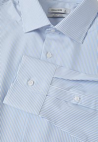 Camicia a righe blu chiaro con colletto button-down, design slim fit e due bottoni frontali. Il materiale sembra liscio e facile da stirare.