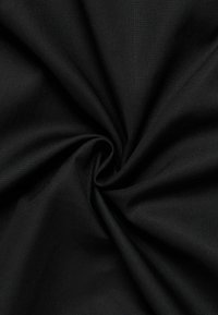 Tessuto di cotone nero con una superficie liscia, tessuto in modo stretto, caratterizzato da una piega a spirale che evidenzia la sua durabilità e il colore uniforme.