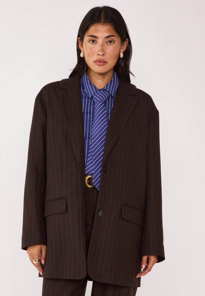 Blazer marrone a righe sottili realizzato in tessuto texturizzato, con rever a punta, chiusura con un solo bottone e due tasche frontali.