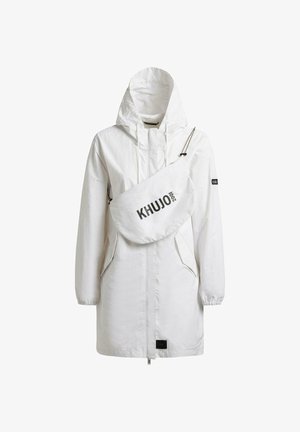 Witte lange jas met capuchon en voorzakken, gecombineerd met een witte schoudertas met het label "KHUJO 2001", tegen een witte achtergrond.