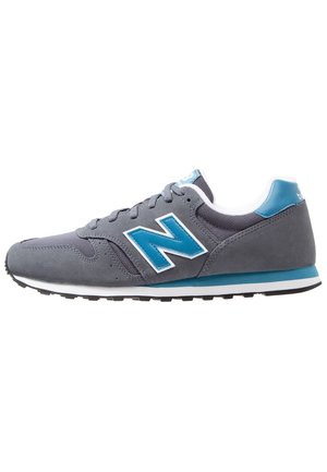 Szaro-niebieski sneaker marki New Balance z sznurowanym przodem, cholewką z siateczki i zamszu oraz białą amortyzowaną podeszwą z czarnym bieżnikiem.