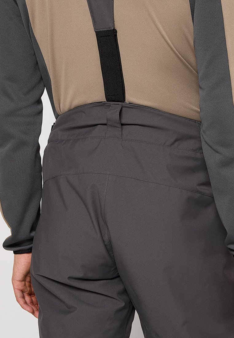 Szare wodoodporne kombinezony z regulowanymi czarnymi ramiączkami. Charakteryzują się gładką teksturą, elastycznym pasem i wzmocnionymi szwami dla większej trwałości.