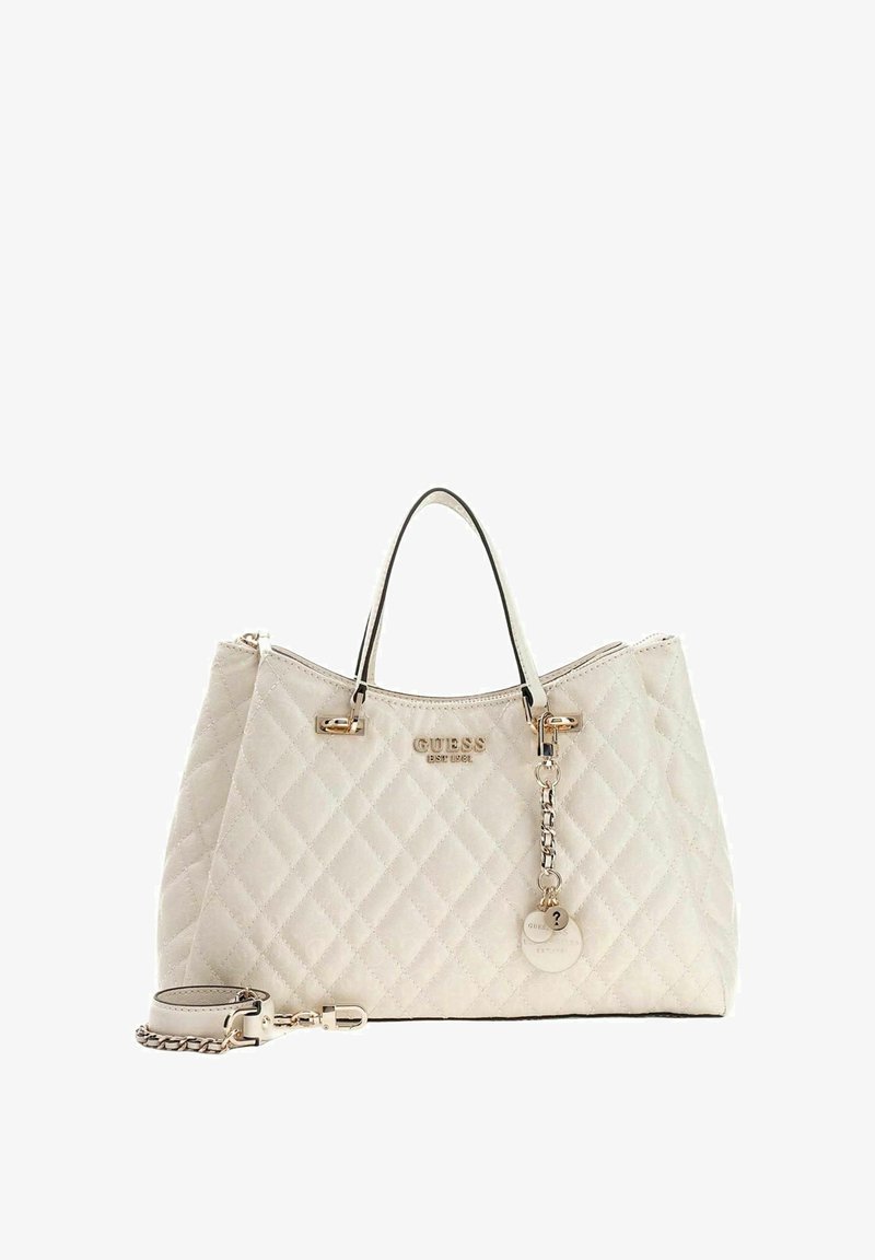 Sac à main beige matelassé avec ferrures dorées, deux poignées supérieures, une bandoulière amovible et une étiquette logo. Texture lisse avec motif en losanges.