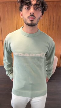 Maglione verde menta con maniche lunghe e collo a costine. Presenta un logo "YAC" in contrasto sul petto e orlo a costine.