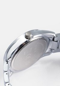 Ανδρικό ρολόι από ανοξείδωτο ατσάλι με στρογγυλή ασημένια θήκη, υφασμένη κορώνα και μπρασελέ τύπου; διαθέτει λείο, γυαλισμένο φινίρισμα.