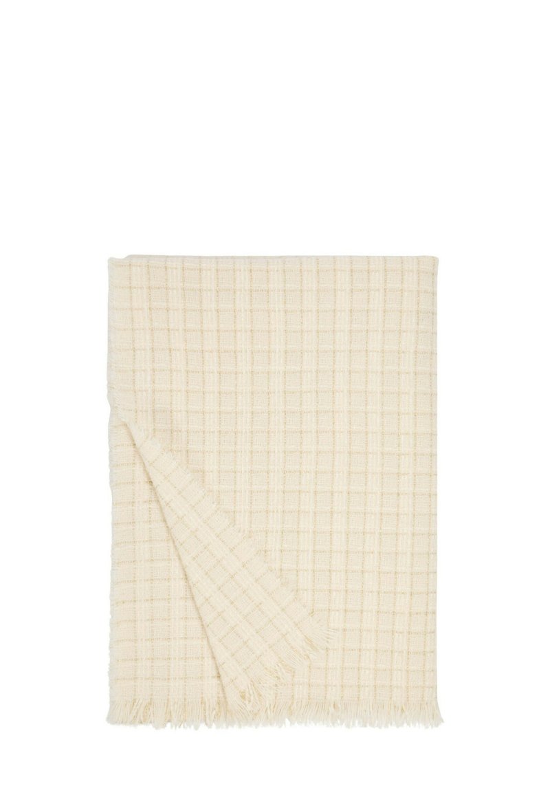 Coperta in cotone di colore crema con un motivo a quadri testurizzato e frange lungo un bordo.