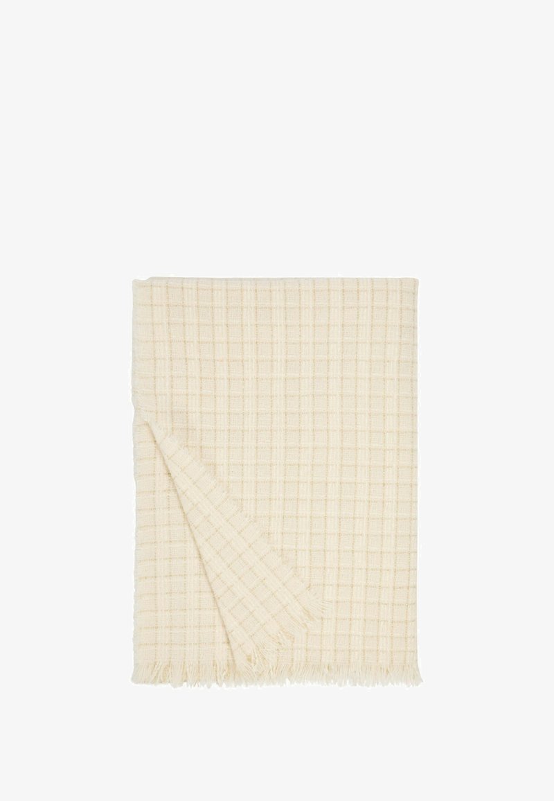Coperta in cotone di colore crema con un motivo a quadri testurizzato e frange lungo un bordo.
