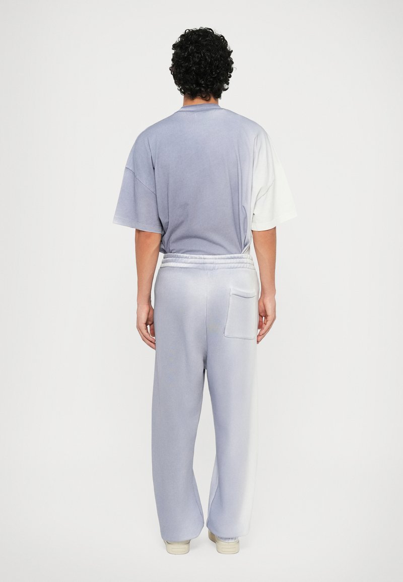 Set di pantaloni della tuta e maglietta oversize in tie-dye lilla e bianco; presenta una vestibilità comoda, vita elastica e dettagli della tasca posteriore.