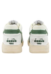Zapatillas blancas y verdes con parte superior de ante y malla. Cuenta con suelas de goma, collar acolchado y logo "diadora 1990" en el talón.