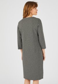 Vestito a lunghezza ginocchio in bianco e nero con motivo, maniche a tre quarti, scollo a girocollo e vestibilità rilassata, realizzato in tessuto tessuto con texture.