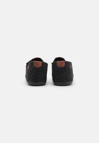 Grå filt slippers med en afrundet form, brune læderhæle og sorte gummisåler. Simpelt design, blød tekstur og minimal detaljering.