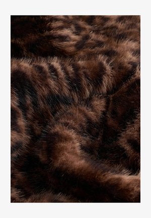 Ruda dirbtinė kailio medžiaga su tekstūruota paviršiumi, kuriame matomos tamsios juostos. Minkšta, puri medžiaga sukuria šiltą, taktilinį vaizdą.