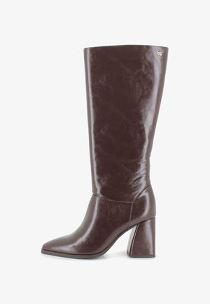 Bota de cuero marrón oscuro hasta la rodilla con tacón cuadrado y punta afilada, que presenta un pequeño logotipo dorado cerca del borde superior en el lado exterior.