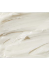 Texture crémeuse et blanche, lisse avec des ondulations et des ridges subtiles, ressemblant à une lotion ou une crème épaisse. Aucune particule ou ornement visible.