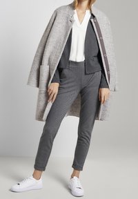 Szary wełniany płaszcz, biały bluzka z dekoltem w serek, czarno-biała marynarka w jodełkę, szare spodnie i białe trampki. Cechuje się prostymi liniami i dopasowanym krojem.