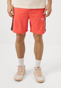 Korali sportske kratke hlače s tamnoplave bočne pruge, logotip na lijevom bedru, izrađene od laganog materijala. Imaju elastičnu siluetu i opušteni kroj.