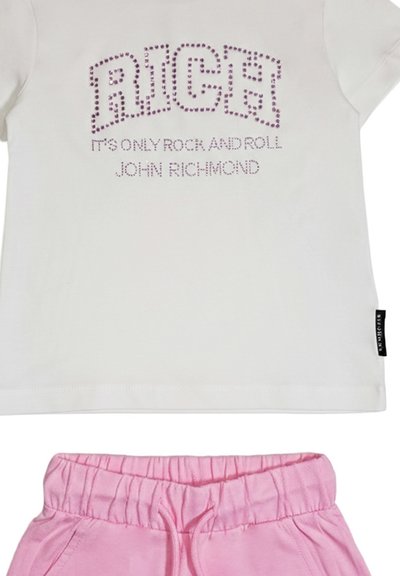 T-shirt bianca corta con scritta "RICH" in strass rosa e testo "It's Only Rock and Roll John Richmond", abbinata a pantaloncini con vita elastica rosa.