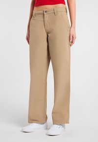 Beige, ruime broek gemaakt van een duurzame stof, met een standaard tailleband, voor- en achterzakken, en een rechte zoom.