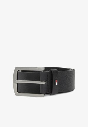 Mustast tekstuuriga nahast vöö hõbedase ristküliku kujulise pandla ja väikese punase, valge ning musta lipu embleemiga aasas.