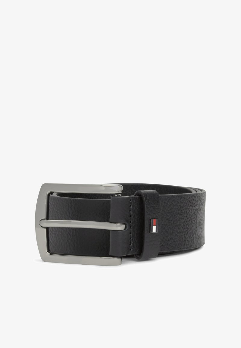 Melnas faktūras ādas josta ar sudraba taisnstūrveida sprādzi un mazu sarkanas, baltas un melnas karoga emblēmu pie cilpas.