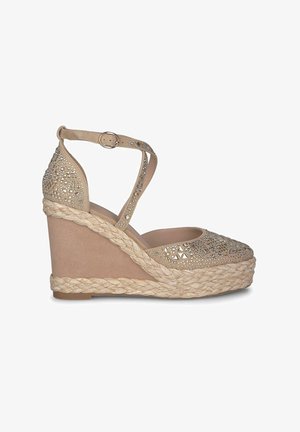 Sandales compensées beiges avec une semelle en jute tissée. Tige en matériau texturé, ornée de strass et de motifs géométriques. sangle ajustable.