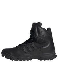 Bottines montantes noires en cuir et mesh, avec des accents texturés, six œillets pour les lacets et une semelle robuste pour une bonne traction.