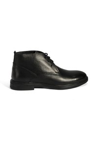 Bottines en cuir noir avec une finition texturée, un bout lisse et une semelle en caoutchouc plate. Elles présentent des lacets et des détails de couture minimalistes.